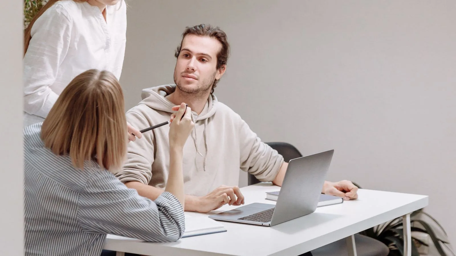 Trois collègues en réunion de travail autour d'un ordinateur portable